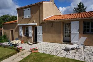 a house with a patio and a table and chairs at La Bourie in Le Girouard