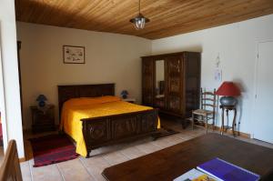 a bedroom with a bed and a table and a chair at La Bourie in Le Girouard