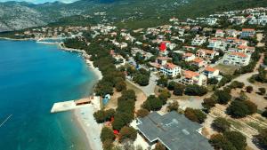 z góry widok na plażę z domami i ocean w obiekcie Apartments Valentinovo w mieście Klenovica