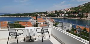 un balcone con tavolo e sedie e vista sull'acqua di Apartments Mia Bilo a Podgreben