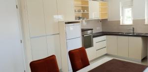 a kitchen with white cabinets and a sink at Apartments Mia Bilo in Podgreben