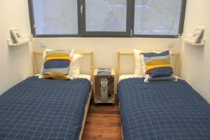 2 camas en una habitación con 2 ventanas en Bonjardim Flats - T2 com Varanda, en Oporto