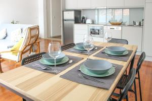 una mesa de madera con platos y copas de vino. en Bonjardim Flats - T2 com Varanda, en Oporto