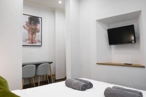 a room with a bed and a tv on the wall at The Gallery 42 Guest House in Florence
