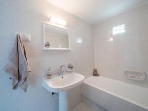 a white bathroom with a sink and a bath tub at Villa Dirui in Fodele