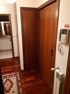um corredor com uma porta de madeira e uma televisão na parede em My Home in OPorto em Maia