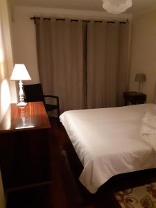 a bedroom with a bed and a table with a lamp at My Home in OPorto in Maia +46 photos