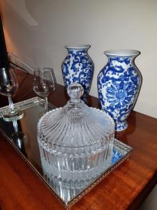two blue and white vases on a table with glasses at My Home in OPorto in Maia