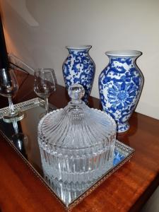 dos jarrones azules y blancos en una mesa con gafas en My Home in OPorto, en Maia