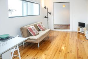 - un salon avec un canapé et du parquet dans l'établissement Bonjardim Flats - T1 + 1 com terraço, à Porto