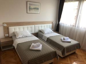 two beds in a room with towels on them at Leo in Niš