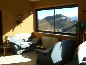 a living room with two chairs and a large window at Hotel Ambasciatori in Calitri