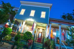 a blue house with flags in front of it at HOSTEL Auberge NOLA in New Orleans
