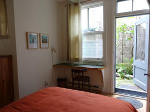 a bedroom with a bed and a desk next to a window at Gite à Coté in Montréal