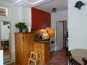 a kitchen with red cabinets and a wooden counter top at Gite à Coté in Montréal +17 photos
