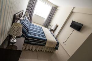 Un dormitorio con una cama con una ventana grande. en Apartamento Familiar Ideal, en Cochabamba