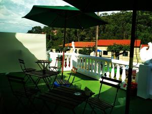 d'une terrasse avec des chaises et un parasol sur le balcon. dans l'établissement Mar de Rosas, à O Grove