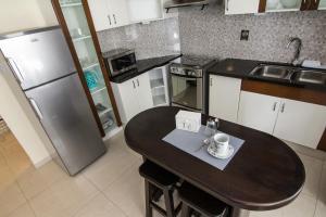 Il comprend une petite cuisine équipée d'une table et d'un réfrigérateur. dans l'établissement Apartamento Familiar Ideal, à Cochabamba