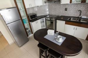 a small kitchen with a table and a refrigerator at Apartamento Familiar Ideal in Cochabamba