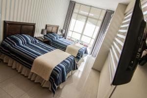 Dos camas en una habitación con ventana. en Apartamento Familiar Ideal, en Cochabamba