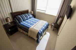 Habitación pequeña con cama y ventana en Apartamento Familiar Ideal en Cochabamba