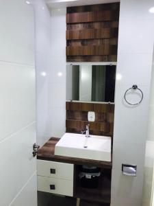 a bathroom with a white sink and a mirror at Apartamento 401 Edificio London in Piratuba