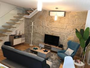 un soggiorno con divano, TV e scale di URBAN VIEWS Terrace - Duplex Apartment "Luis I" a Porto
