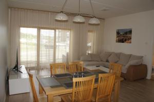 a dining room and living room with a table and chairs at Kotkapoja Apartment in Kuressaare