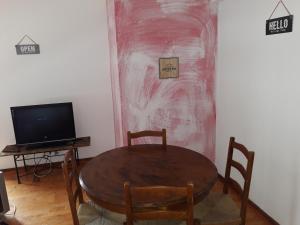 a dining room with a table and a television at Âncora da Foz in Figueira da Foz