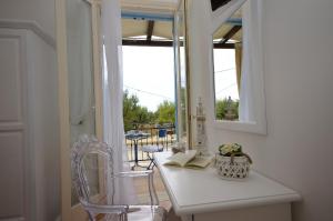 カステッルッツォにあるCatarin Comfort Roomsの窓付きの客室で、白いテーブルと椅子が備わります。