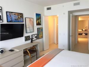 a bedroom with a bed with a desk and a tv at C y H Residences Hyde in Hollywood