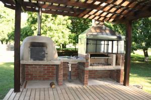 um forno exterior com um telhado num deque em Cabaña Aroma de Campo em Villarrica