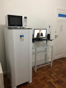 a desk with a microwave and a computer on it at Casa Max in Fortaleza