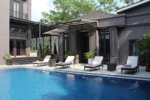 una piscina con sedie a sdraio accanto a una casa di Sofia Boutique Residence a Yogyakarta