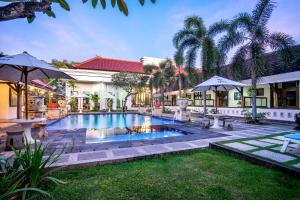 een zwembad in de tuin van een huis bij Inna Bali Heritage Hotel in Denpasar