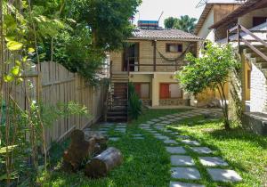 un jardín con un camino de piedra frente a una casa en Adora Suites, en Abraão