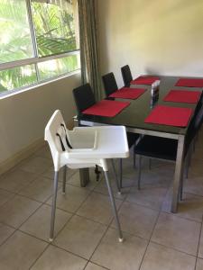 a dining room with a table and a white chair at Cairns Golf Course Apartment in Cairns