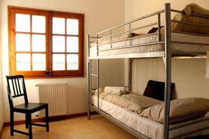 - une chambre avec 2 lits superposés et une chaise dans l'établissement Villa Catalana, à Calonge