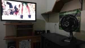 uma sala de estar com uma televisão e uma ventoinha em Casa em Fortaleza