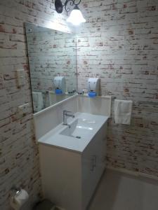 y baño con lavabo blanco y espejo. en La Casa Te Puru Lodge en Te Puru