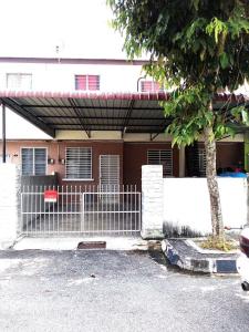 une clôture devant une maison avec un arbre dans l'établissement Kak Chik Muslim Homestay, à Kepala Batas