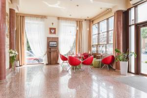 a living room with red chairs and a table at Domus Mater Hotel in Kraków