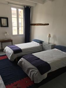 - une chambre avec 2 lits et une fenêtre dans l'établissement Cosy Medieval Village House Monségur, à Monségur