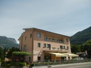 a building with a balcony with tables and umbrellas at Albergo Miralaghi in Padergnone