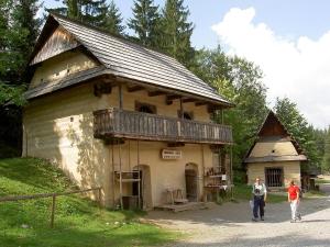 two people walking in front of an old building at Apartmánový dom Adriana in Zuberec