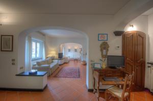 een woonkamer met een bank en een tv bij Appartamento in Villa a 5 KM dal mare in Albisola Superiore