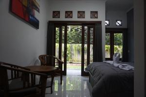 a bedroom with a table and a bed and a table and chairs at Mai Guesthouse in Sanur