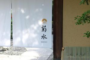 a sign with asian writing on the side of a building at Nanzenji sando KIKUSUI in Kyoto