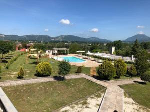 a resort with a swimming pool and mountains in the background at Agriturismo Quartuccio in Oricola