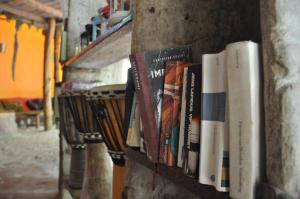 un mucchio di libri su uno scaffale su un muro di Sagando Bungalows Zanzibar a Michamvi Kae